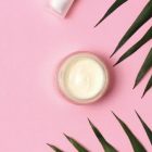 A pot of face cream on a pink background