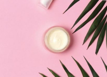 A pot of face cream on a pink background