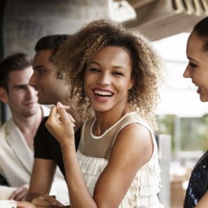 Woman laughing with friends at bar