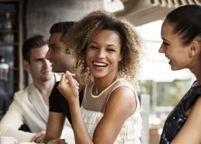 Woman laughing with friends at bar