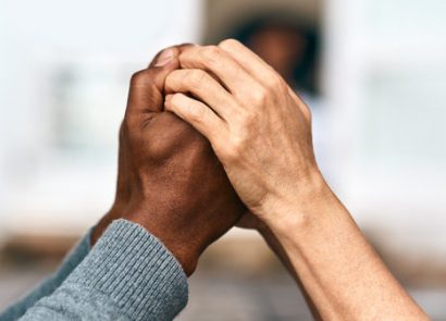 Two sets of hands clasping each other