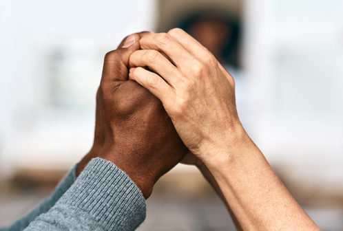 Two sets of hands clasping each other