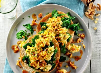 A bagel topped with scrambled egg, walnuts and paprika