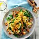 A bagel topped with scrambled egg, walnuts and paprika