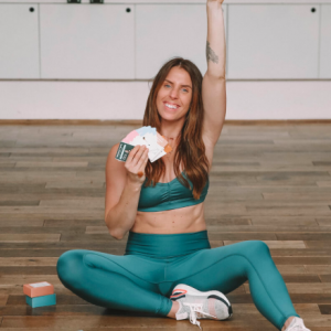 Personal trainer Carly Rowena showing her new workout cards and making peace sign