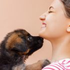 Woman being licked by puppy