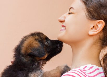 Woman being licked by puppy