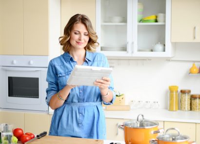 Woman in kitchen using tablet