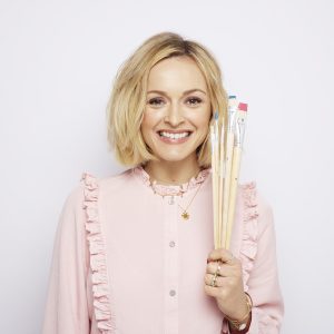 Fearne Cotton smiling and holding a set of paint brushes