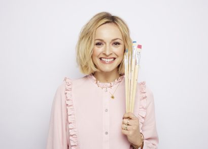 Fearne Cotton smiling and holding a set of paint brushes