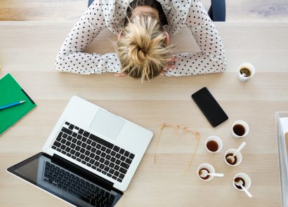 Young business woman napping at her desk to conquer Blue Monday