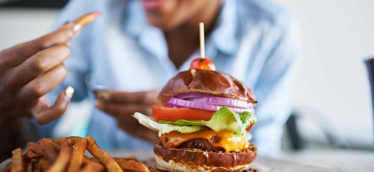 Woman getting ready to enjoy a burger and chips at the weekend