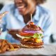 Woman getting ready to enjoy a burger and chips at the weekend