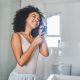 Woman brushing her hair inside her bathroom, after learning not to make these hair mistakes