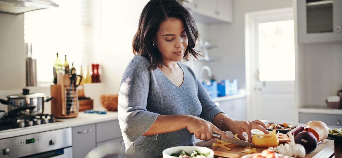 Young mum cooking her favourite dish to boost her wellbeing