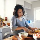 Young mum cooking her favourite dish to boost her wellbeing