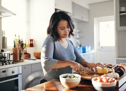 Young mum cooking her favourite dish to boost her wellbeing