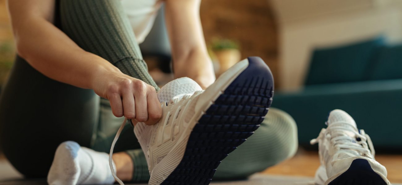 Woman putting on trainers for indoor workout