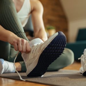 Woman putting on trainers for indoor workout