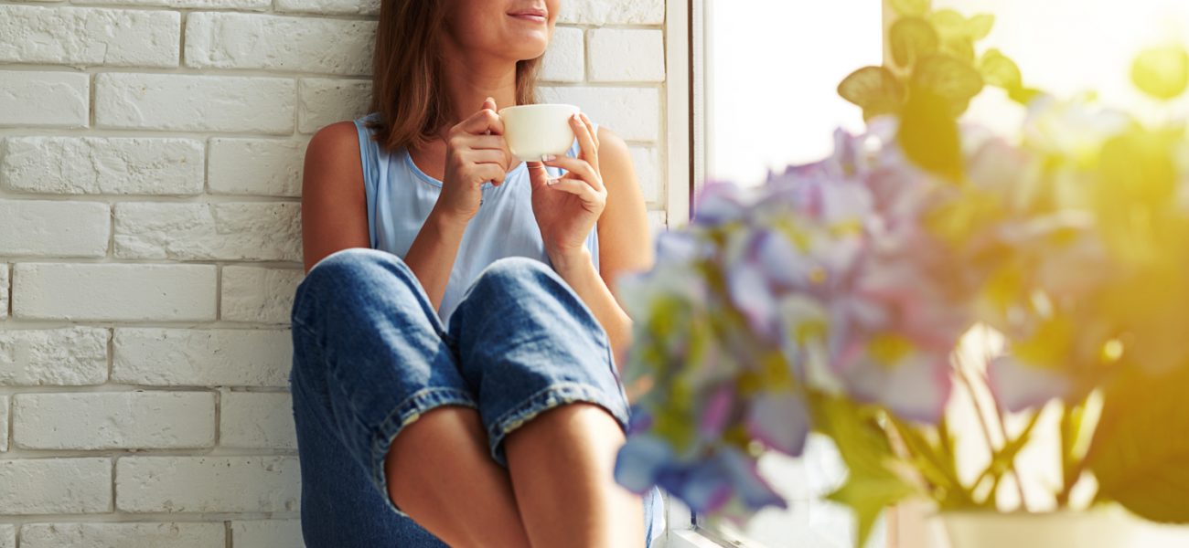 A woman enjoying a mug of tea, healthy with well-balanced hormones