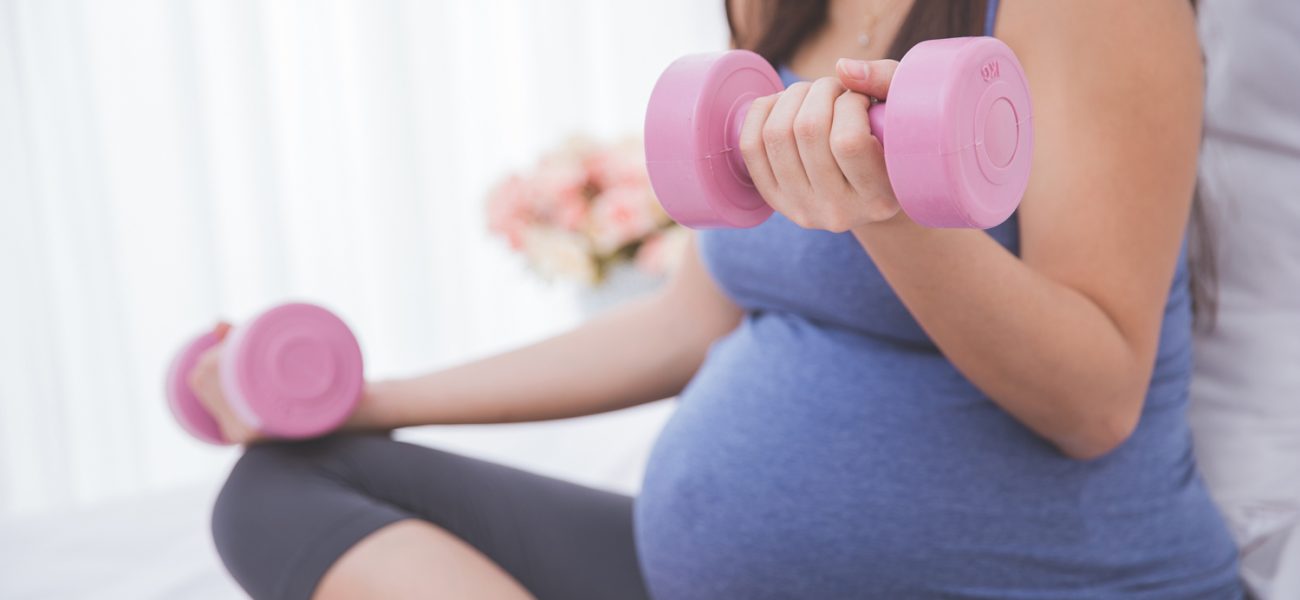 Woman enjoying some exercise with small weights while pregnant