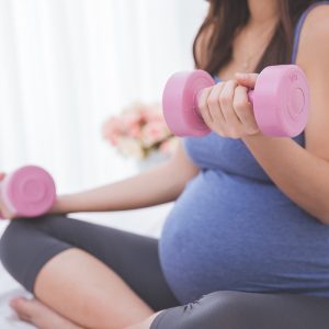Woman enjoying some exercise with small weights while pregnant