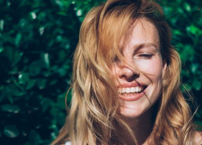 Woman smiling in the sunshine, enjoying vitamin D