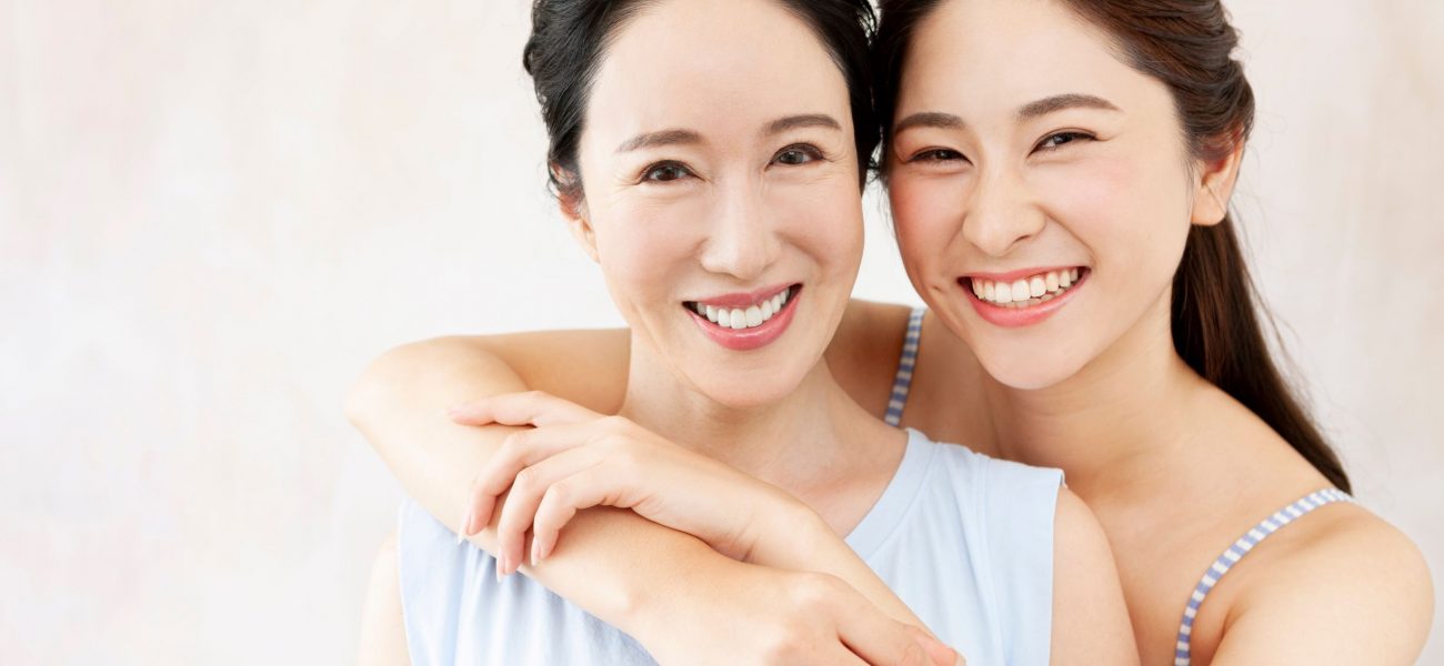 Mother and daughter with clear skin smiling