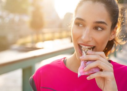 woman outside eating protein bar healthy snack