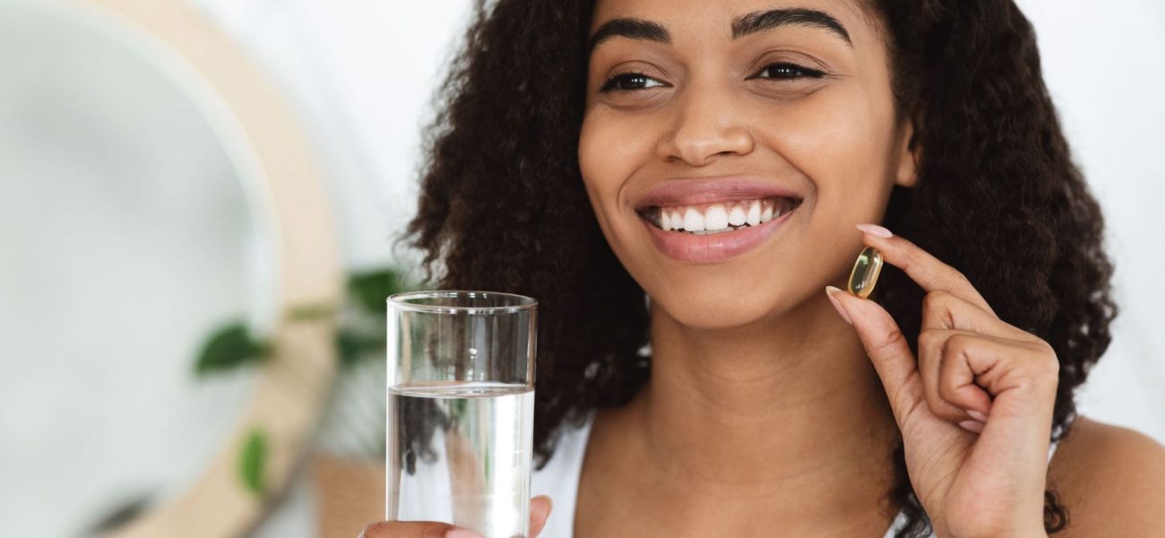 woman taking supplement with water