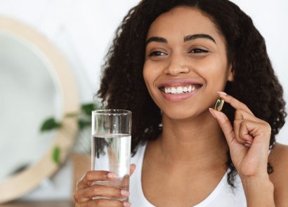 woman taking supplement with water