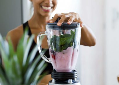 woman making a healthy smoothie in a blender