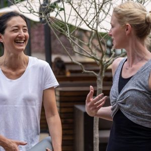 two girlfriends going to exercise together with their mats