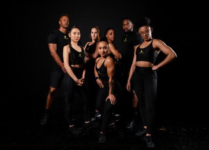 diverse group of personal trainers posing on a black background