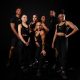 diverse group of personal trainers posing on a black background
