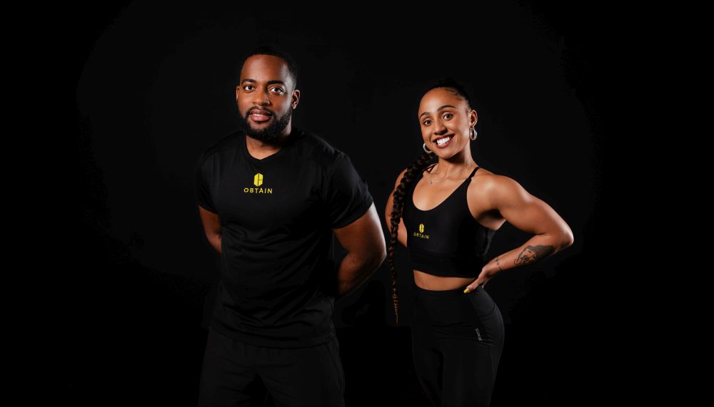 fit man and woman of colour from an inclusive fitness platform pose in gym gear