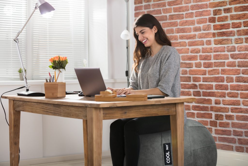 woman working at desk sitting on a stability ball