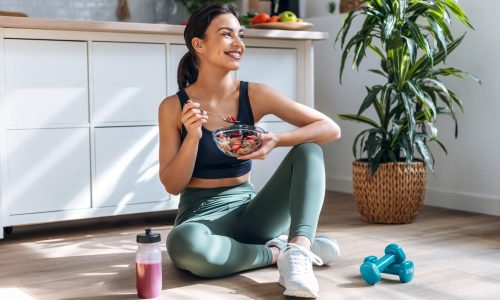 A form eating a healthy breakfast in fitness clothes