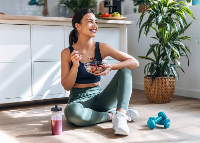A form eating a healthy breakfast in fitness clothes