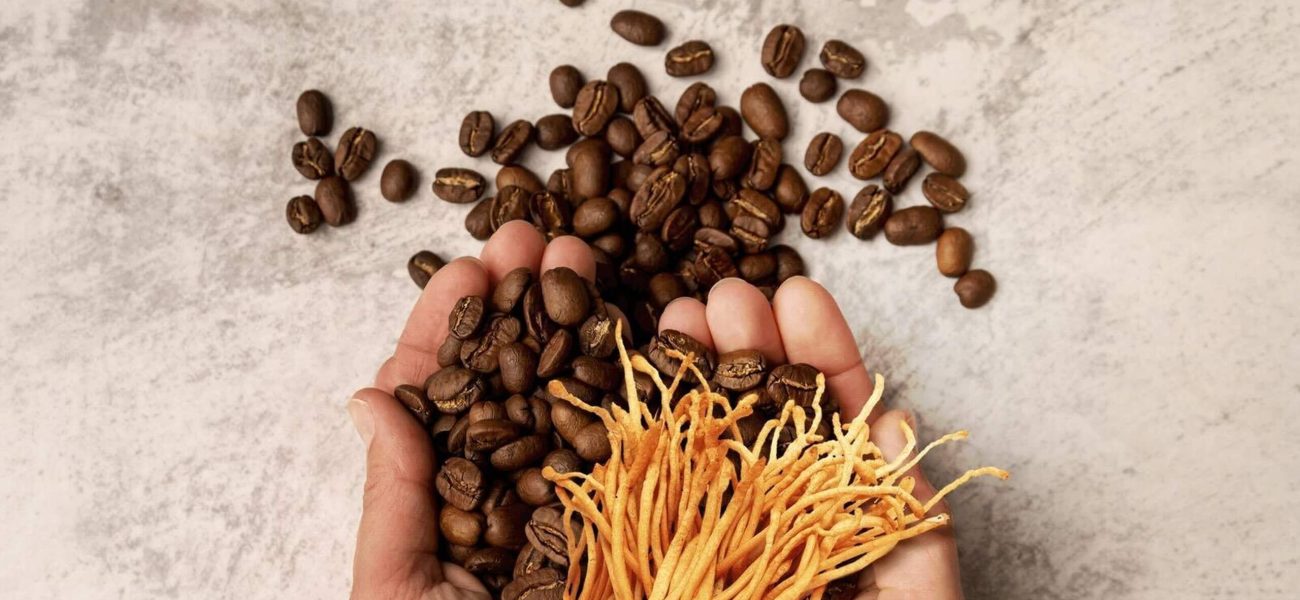 Two hands holding coffee beans