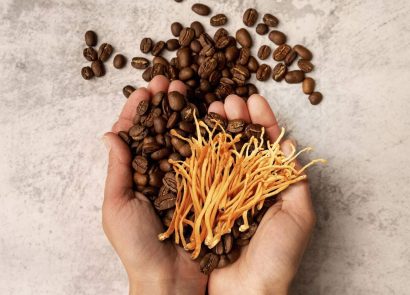 Two hands holding coffee beans