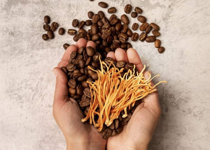 Two hands holding coffee beans