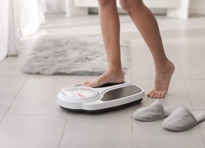 A woman stepping onto a set of scales