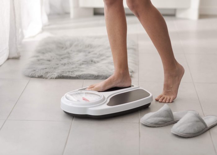 A woman stepping onto a set of scales