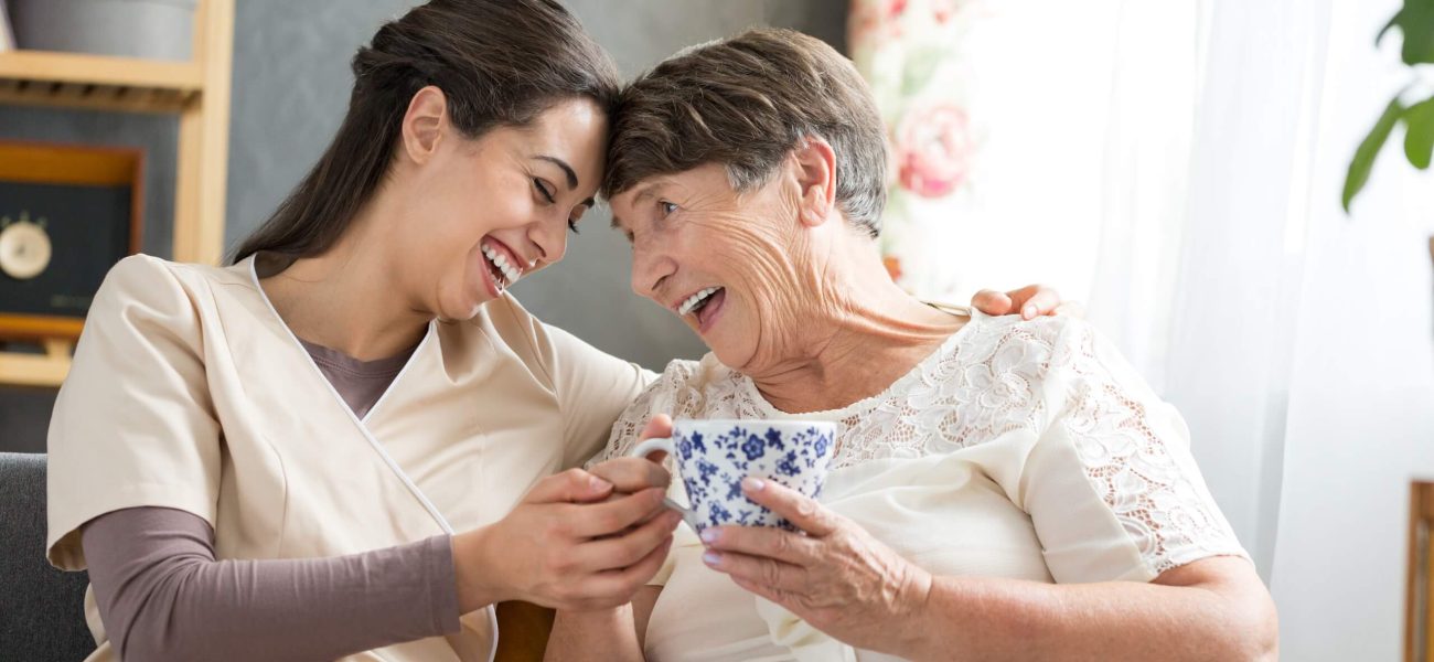 A woman and her grandmother laughing together