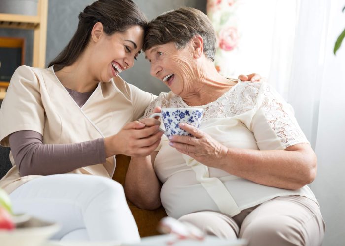 A woman and her grandmother laughing together