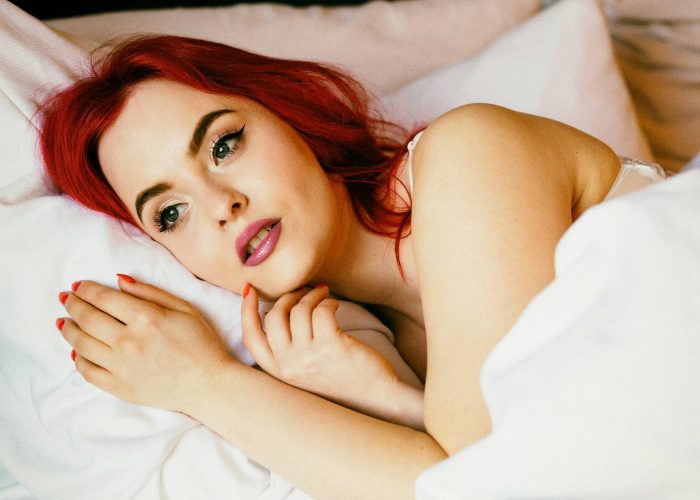 A woman lying bed under a duvet