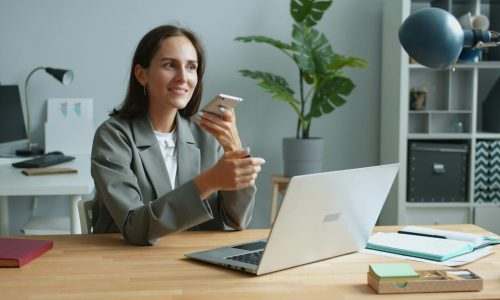 A woman in an office speaking on the phone
