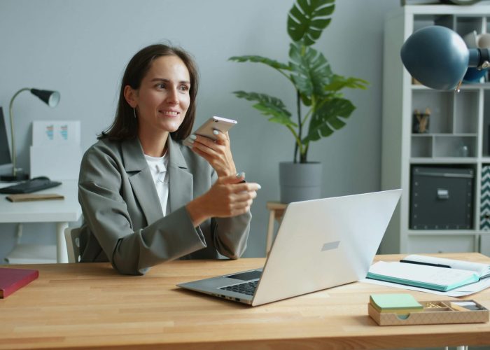A woman in an office speaking on the phone