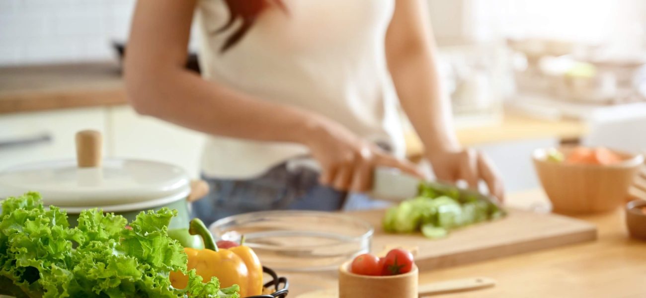 A woman chopping vegetables in a kitchen